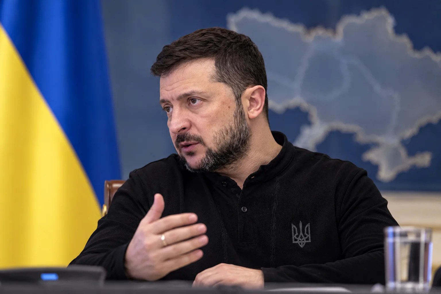 Der ukrainische Präsident Wolodymyr Selenskyj spricht bei einer offiziellen Sitzung vor ukrainischer Flagge und Karte über die Finanzierung der Verteidigung.